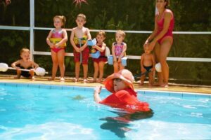 Miss Jackie Teaching Children To Swim Across Pool